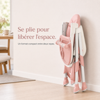 Chaise haute pliable E500 rose poudré pliée et rangée debout contre un mur